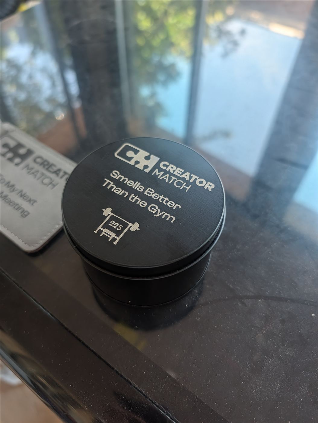 Black candle tin with a company logo and custom message engraved on the lid