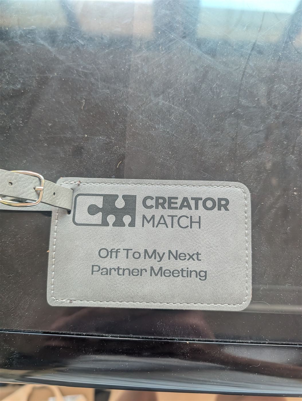 Gray leatherette luggage tag engraved with a company logo and custom message